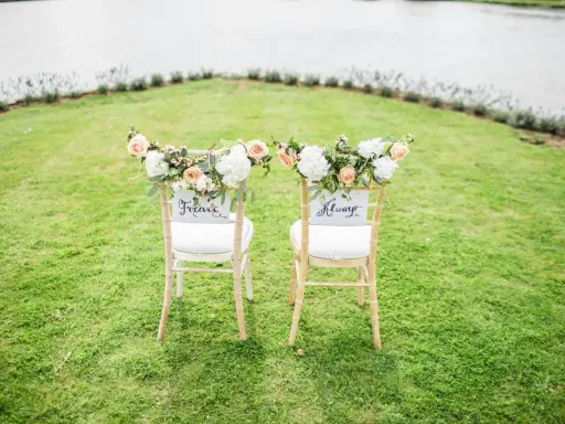 Zwei festlich geschmückte Stühle im Grünen, bereit für eine goldene Hochzeit im kleinen Kreis. "Forever" und "Always" stehen für die Ewigkeit.