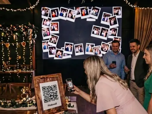 Eine Frau scannt mit ihrem Handy einen QR-Code für eine Photowall. Eine tolle Idee für ein Hochzeitsprogramm mit vielen Erinnerungsfotos.