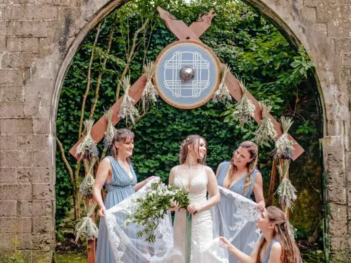 Braut und Brautjungfern unter einem Torbogen mit Wikinger-Schild. Eine stimmungsvolle Wikinger-Hochzeit.