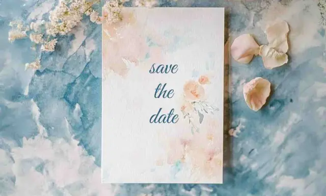 Eine Save the Date Karte mit zarten Aquarellblumen auf blauem Marmorgrund.