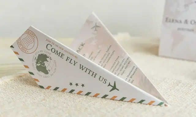 Einladung zur Hochzeit im Papierflieger-Design. Der lustige Text "Come fly with us" lädt zur gemeinsamen Reise ein.