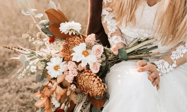 Brautstrauß mit Dahlien, Rosen und Orchideen in warmen Tönen. Originelle Ideen Hochzeit für einen rustikalen Look.