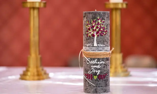 Eine liebevoll gestaltete Hochzeitskerze mit Baum, Namen und Herz. Ein schönes Symbol für die Liebe.