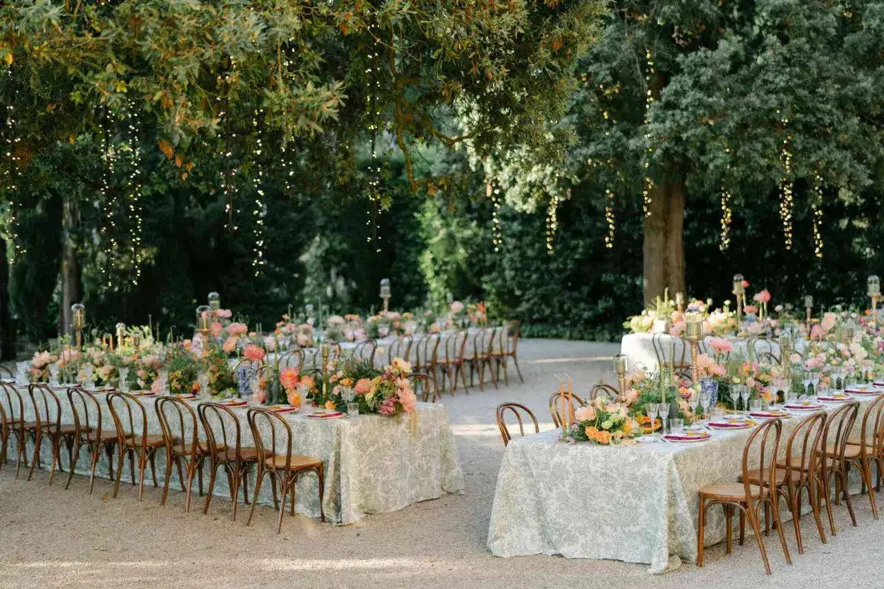 Festlich gedeckte Tische im Freien, geschm&uuml;ckt mit Blumen und Lichterketten. Perfekt, um eine Hochzeit locker feiern zu k&ouml;nnen.