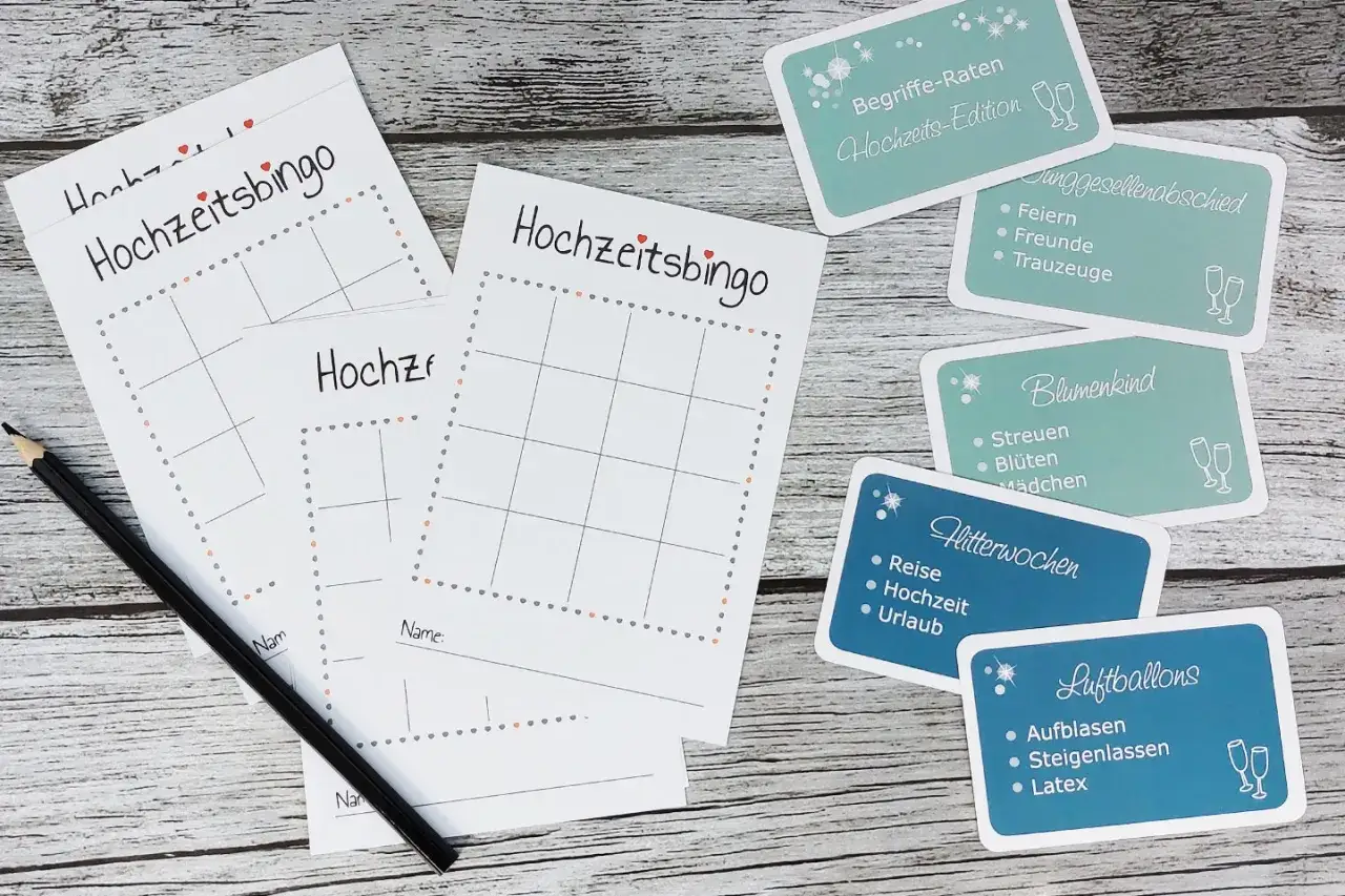 Hochzeitsbingo-Karten und thematische Karten f&uuml;r Spiele zur Hochzeit, wie Junggesellenabschied und Flitterwochen. Ein Bleistift liegt bereit.