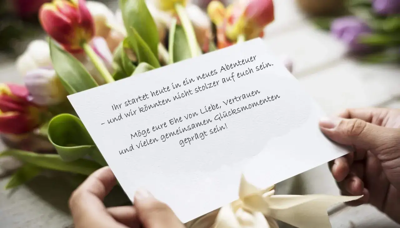 Hände halten eine Karte mit Glückwünschen vor einem Tulpenstrauß. Mein Sohn heiratet heute und wir sind unglaublich stolz!