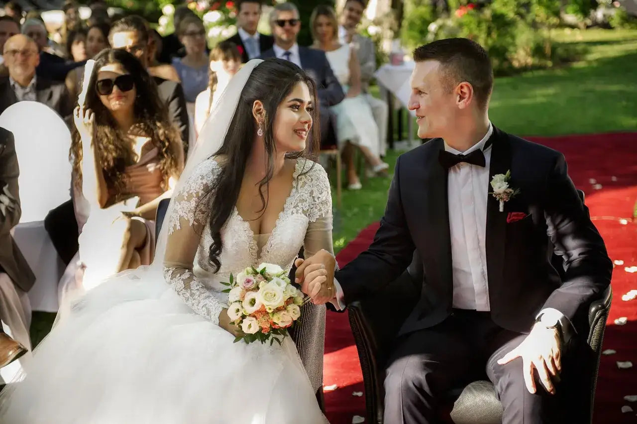 Brautpaar h&auml;lt H&auml;ndchen bei einer wundersch&ouml;nen Zeremonie. Welche Hochzeiten gibt es? Diese hier ist voller Liebe und Freude.
