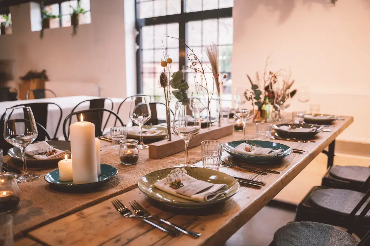Festlich gedeckter Tisch f&uuml;r eine Hochzeit im kleinen Kreis. Kerzen, Blumen und Weingl&auml;ser schaffen eine intime Atmosph&auml;re.
