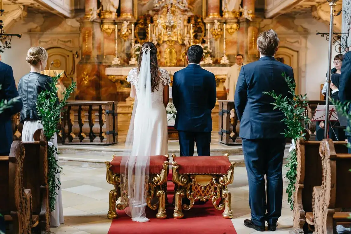 Brautpaar steht vor dem Altar. Nur ein Partner in der Kirche, der Br&auml;utigam, blickt zum Priester.
