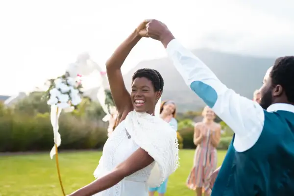 Glückliches Brautpaar tanzt im Freien. Viele Paare entscheiden sich für eine Sommerhochzeit, denn dann heiraten die meisten.